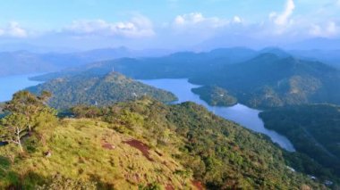 Sri Lanka 'nın muhteşem manzaralarının üzerinde uçmak. Tepeden bakan bir gölü olan yüksek dağlar..