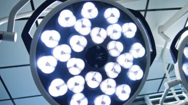 Ameliyathanenin tavanındaki lambaları iki büyük yuvarlak açtı. Hastanedeki aydınlatma ekipmanının düşük açılı görüntüsü.