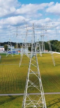 Enerji dağıtımı. Elektrik direkleri devrede. Yazın elektrik taşımacılığı endüstrisi. Enerjiler. Kablolu elektrik hatları. Dikey video