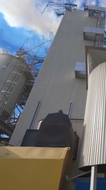 Modern bir kompleksin alüminyum teçhizatı. Tahıl işleme sırasında büyük tarım fabrikasından gelen kalın beyaz duman havaya karışır. Dikey video