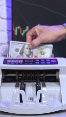 Geniş ekran arka planda modern sayaç makinesi. Adamın eli kağıt parayı bir sayım makinesine koyuyor ve onları finansal operasyondan sonra alıyor. Dikey video