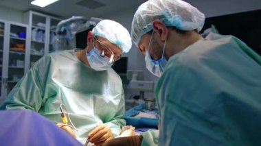 Cerrahi hoparlörlerdeki baş cerrah modern alet kullanıyor. Sıhhiyeye yardım metal enstrüman uygular.