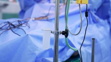 Ameliyathanede damar yolu açın. İki doktor arka planda ameliyat yapıyor..