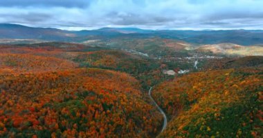 Vermont, New England, ABD 'nin sık ormanlarındaki parlak ağaçlar. Sonbaharda dağlara hava perspektifi. Manzaranın üzerindeki dramatik bulutlar.