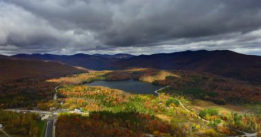 Dağlarla çevrili gölün üzerinde dramatik bulutlar toplandı. Vermont doğası, New England, ABD sonbaharda. Hava görünümü.
