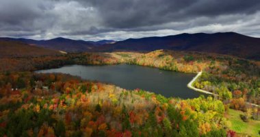 Göl yüzeyi üzerinde asılı gri bulutları yansıtıyor. Sonbaharda Vermont, New England, ABD 'nin dağlık arazisi. Hava görünümü.
