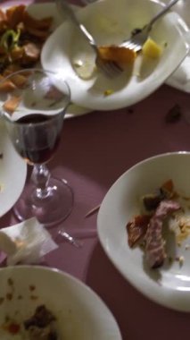 Beyaz tabaklardaki artıklar şenlik masasında. Kamera hareketi dikey video