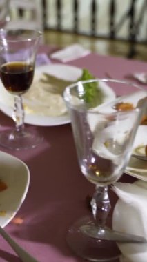 Ziyafetten sonra et tabakları ve atıştırmalıklar festival masasında. Kamera hareketi sağa doğru. Bulanık arkaplan dikey video