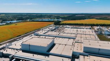 Sarı tarımsal tarlalarla çevrili sanayi tesisi. Fabrikanın çatısındaki drone görüntüleri..