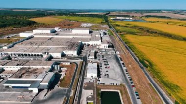 Tarlalardaki modern endüstriyel bir fabrikanın geniş bir bölgesi. Güneşli bir günde kuruluşun üstündeki İHA görüntüleri.
