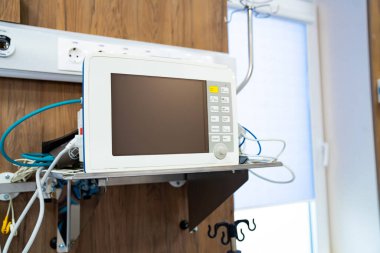 Hasta bakımı için duvara monte edilmiş monitör. Hastanenin duvarına bir ekran monitörü yerleştiriliyor. Hastanın hayati belirtilerini ve sağlık verilerini izlemeye hazır..