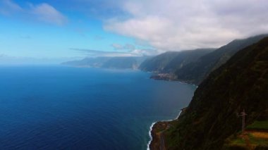 Portekiz 'in Madeira kıyısındaki çarpıcı yüksek dağlar. Bulutlu gökyüzünün altındaki Atlantik Okyanusu manzarası.