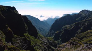 Portekiz, Madeira 'da dik ve tehlikeli yüksek dağlar. Ufuk çizgisi beyaz bulutlarla kaplı. Hava görünümü.