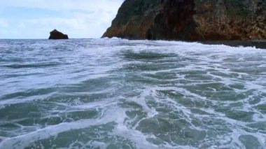 Atlantik Okyanusu 'nun azgın sularının üzerinde uçmak. Köpüklü dalgaların üzerindeki İHA görüntüleri Madeira 'nın kayalık kıyılarına ulaşıyor..