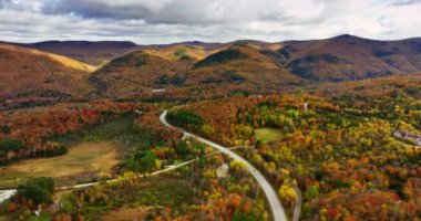 Vermont, New England, ABD 'de sonbahar manzarası. Otoyolun yukarısındaki ağaçlık kayalara giden drone görüntüleri..