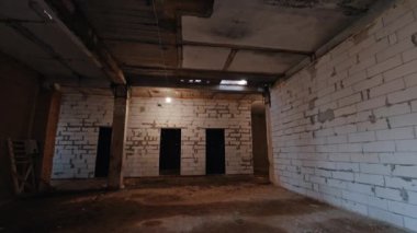 Sütunlu ve beyaz tuğlalı eski püskü bir oda. Kapısı olmayan ve ampulleri açan büyük bir öneri..