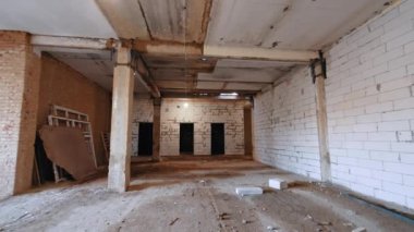 Binanın içinde yeniden yapılanma var. Tuğla duvarlarla çalışan bir adam..