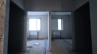 Altında pencere ve radyatör olan iki oda. Binanın içinde yapım aşamasında bir yürüyüş..