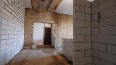 Eski binada yeni inşa edilmiş beyaz tuğlalardan duvarlar. Gün ışığı odaya büyük bir pencereden giriyor..