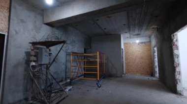 Etrafında kablolar olan elektrik santrali ve tasarlanmamış metal yapı iskelesi. İnşaat halindeki binanın dayanağı.