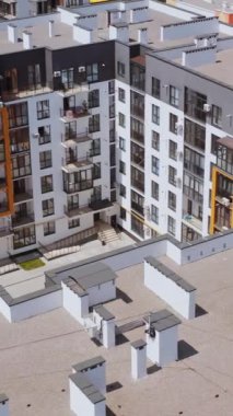 Yeni yerleşim yeri. Yüksek binalar birlikte inşa edildi. Apartman binalarıyla çevrili çocuklar için rahat bir oyun alanı. Üst hava manzarası. Dikey video