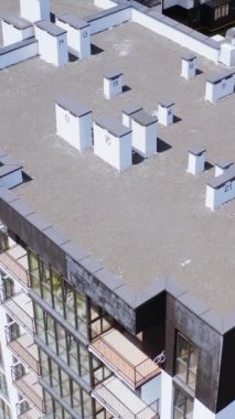 Yüksek binaların çağdaş dış yüzeyi. Modern tasarım şehrinde yeni umumi konut daireleri. Hareket kamerasının üstünü indir. Dikey video