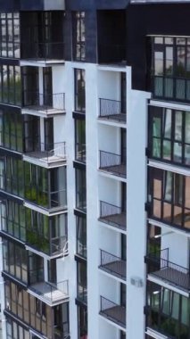 New City semtindeki modern apartman. Çok katlı, güzel koyu pencereli yeni bir binanın dışı. Hava görüntüsü. Dikey video