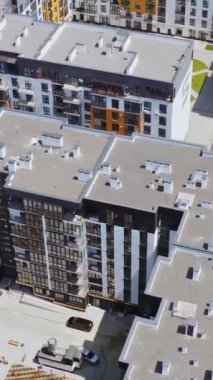 Şehir kompleksindeki çağdaş daireler. Çok katlı binaları olan modern yerleşim yerleri. Yeni uzun konut daireleri. Hava görüntüsü. Dikey video