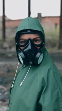 Kıyamet sonrası mekanında olan bir insan. Yeşil koruyucu giysili, gaz maskeli kurtulan kafasını çevirir ve kameraya bakar. Kimyasal saldırıdan sonra harap olmuş. Dikey video