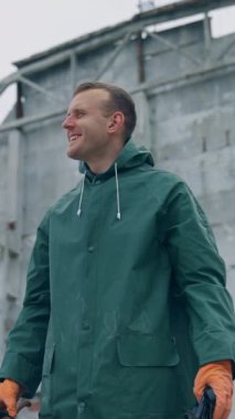 Terk edilmiş bir yerde mutlu bir çevre bilimci. Hayatta kalan adam ellerinde gaz maskesi tutuyor ve yıkılan binanın arka planında temiz hava soluyor. Dikey video