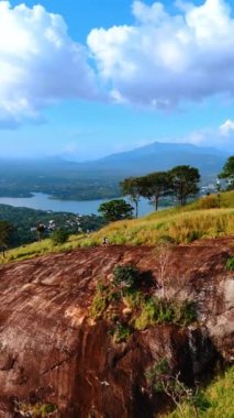 İnsanlar güzel kayanın üzerinde durup doğanın uçsuz bucaksız manzarasını seyrediyorlar. Muhteşem Sri Lanka 'yı gezmek. Dikey video.