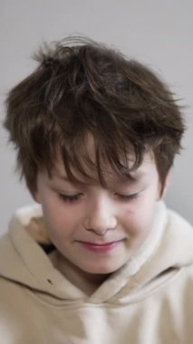 Kameranın önünde poz veren yakışıklı beyaz çocuk. Çocuk ellerini yüzüne koyar, gözlerini ovuşturur ve sonra kollarını yana doğru tembelce uzatır. Dikey video