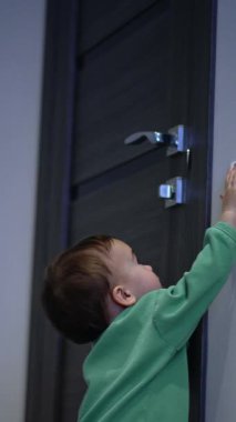 Bir yaşında bir çocuğun elektrik düğmesiyle oynaması çok hoş. Sevimli çocuk ışığı açıp kapayarak kapatıyor. Dikey video