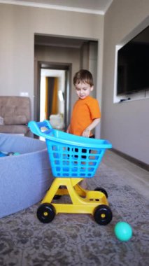 Küçük çocuk bir arabaya yaklaşır ve orada bir top atar. Top tramvaydan fırladı ve çocuk topu kaptı. Dikey video.