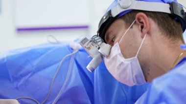 Cerrahın görüntüsü hastanın ameliyat loplarına bakmasına odaklandı. Hastayı ameliyat eden bir erkek doktorun portresi..