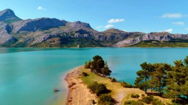 Dağ eteğindeki turkuaz su harika. Güneşli bir günde, çarpıcı yabanın üzerinde İHA uçuşu.