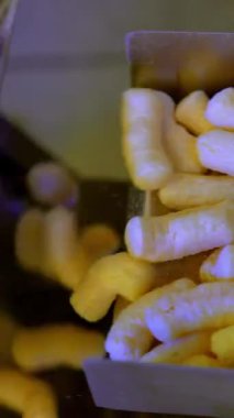 Tatlı gevrek patlamış mısır. Mısır çubuğu fabrikası üretimi. Dikey video