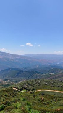 Uçsuz bucaksız kayalık arazi çayırlarla, turist yollarıyla kaplıydı. Mavi gökyüzünün altındaki güzel dağlara hava perspektifi. Dikey video.