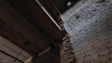 Asansörün boş tuğla şaftı. Düşük açı. Delikleri ve girişi olan eski püskü duvarlar. Yeniden yapılanma kavramı.
