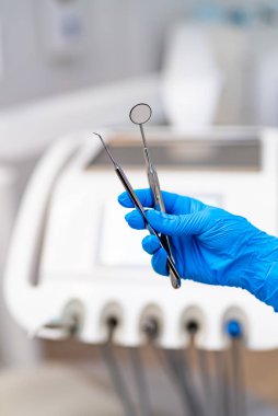 Diş muayenesinde ve tedavide kullanılan aletler. Modern bir klinikte hasta randevusuna hazırlanırken diş hekimi muayene araçları bulundurur..