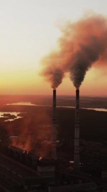 Gün batımı arkaplanındaki güç direklerinin statik görüntüsü. Gün batımında yüksek voltajlı elektrik kulesi. Kumaş konsepti. Seçici odaklanma. Dikey video