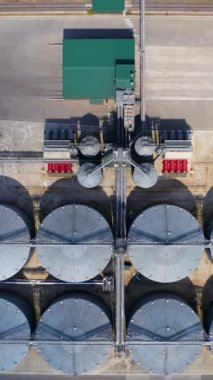 Büyük metal ambarlar. Tarım fabrikası. Tarım tahıl ambarları. Fabrikadaki tahıl asansörü. Üst hava manzarası. Dikey video