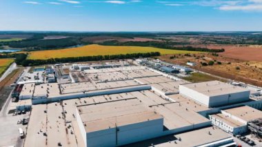 Düz çatıların üzerinde büyük bir sanayi fabrikasının borularıyla uçuyor. Arkaplanda güzel doğal manzaralar.