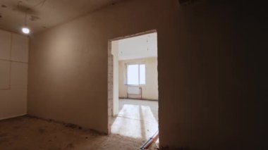 Aşağıdaki iki pencere ve radyatörle boş ışık odasına giriyoruz. Binanın tamamlanmamış inşaatı devam ediyor..