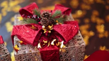 Hediye kutusu ve kırmızı fiyonk şeklinde güzel bir dekor. Çam kozalakları ve köknar ağacı dallarıyla harika bir Noel süsü. Kapat..