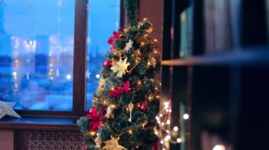 Odanın köşesinde pencerenin yanında duran güzel dekore edilmiş Noel ağacı. Şenlik zamanı, kutlama mevsimi.