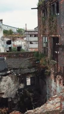 Eski bir fabrikanın kalıntıları. Yıkım için eski endüstriyel bina. Hava görüntüsü. Dikey video