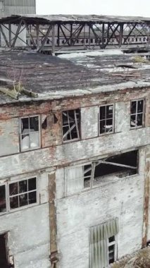 Terk edilmiş endüstriyel fabrika binası, yıkım ve yıkım konsepti. Hava görüntüsü. Dikey video