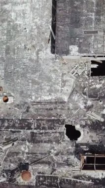 Eski terk edilmiş bir fabrikanın çatısı harabeye dönmüş. Hava görüntüsü. Dikey video