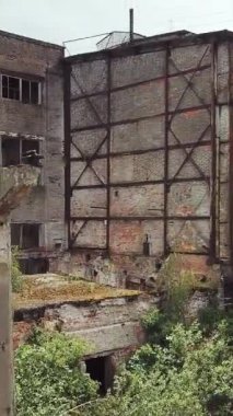Eski bir fabrikanın kalıntıları. Yıkım için eski endüstriyel bina. Hava görüntüsü. Dikey video